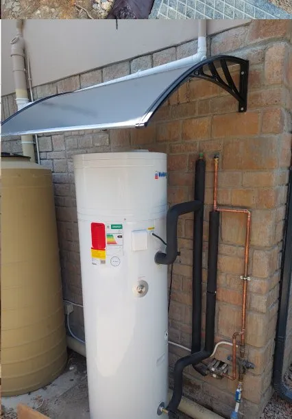 Wall-mounted geyser tank with copper feed pipes.